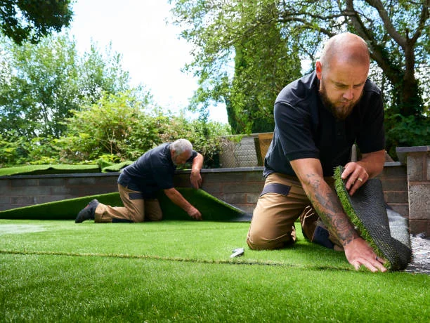 Workers installing artificial grass
